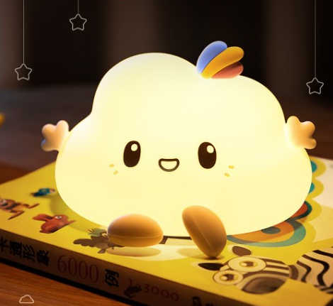 Lampe LED en forme de nuage avec capteur tactile. Bonne qualité et à la mode sur une table au dessus d'un livre dans une maison.