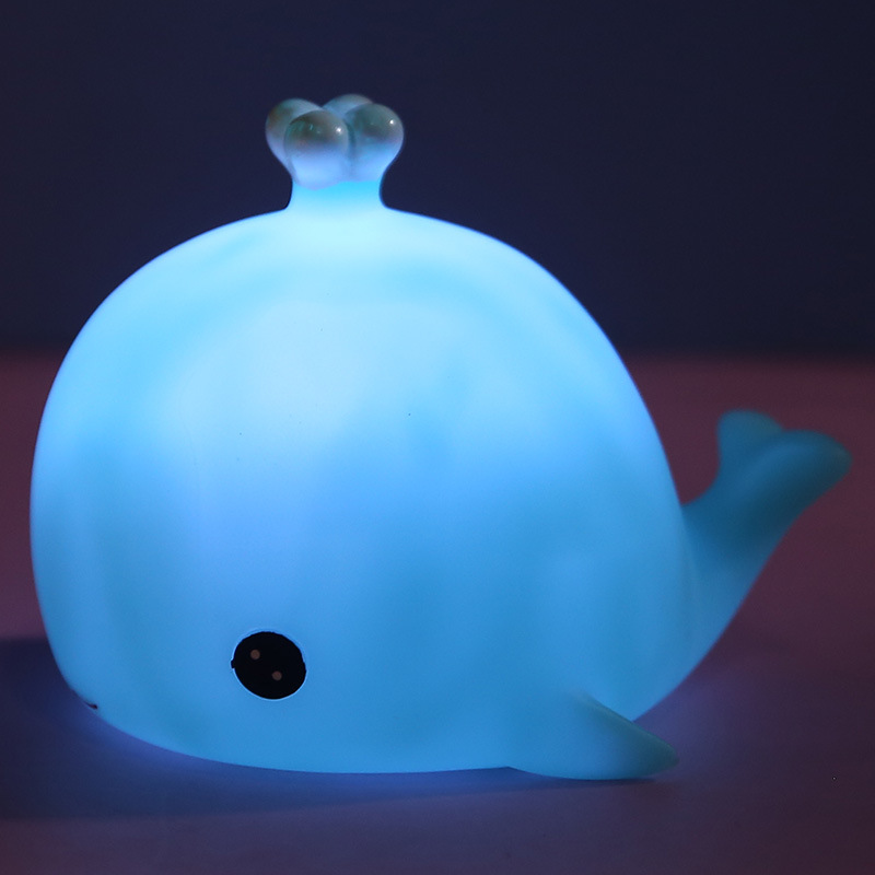 Veilleuse en forme de baleine bleue. Elle a un oeil gros oeil noir ainsi qu'une queue et l'évent au dessus de la tête.