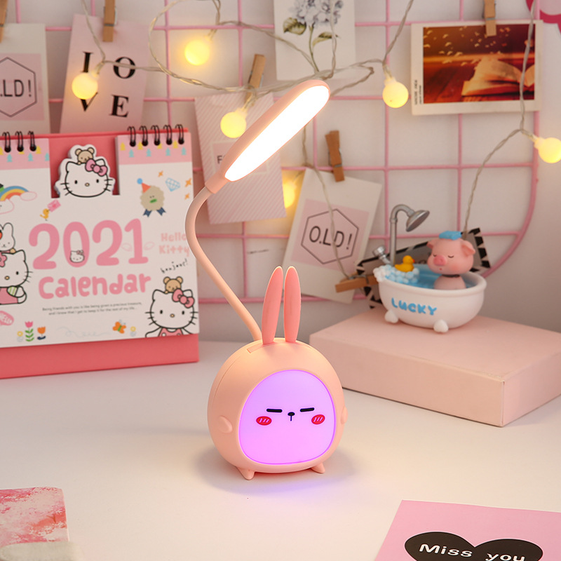 Veilleuse lapin pour chambre à coucher d'enfant. Bonne qualité, et à la mode de couleur rose sur une table avec un calendrier à coté.