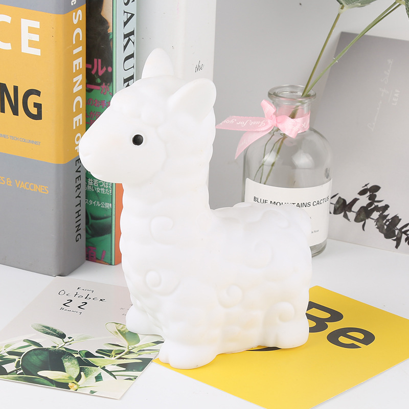 Veilleuse LED en Silicone adorable lama. Bonne qualité et à la mode sur une table à côté d'une livre dans une maison