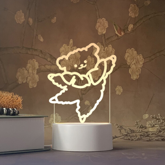 Lampe 3D Ours dansant. Bonne qualité et à la mode sur une table à côté d'une livre dans une maison