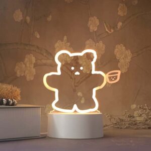 Lampe 3D Ours rigolant. Bonne qualité et à la mode à côté d'une livre dans une maison.