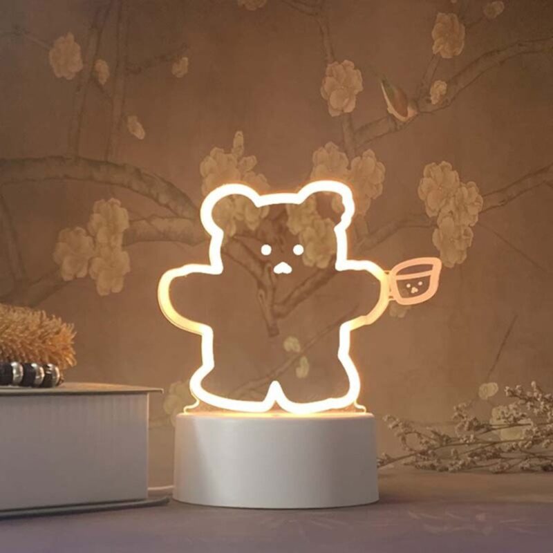 Lampe 3D Ours rigolant. Bonne qualité et à la mode à côté d'une livre dans une maison.
