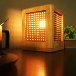 Lampe de chevet carrée en bois massif. Bonne qualité et à la mode sur une table dans une maison