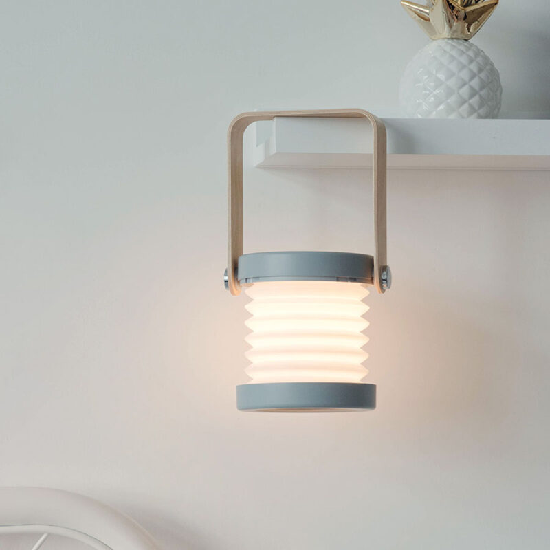 Lanterne portable pliable et tactile à intensité réglable. Bonne qualité, à la mode accrochée sur une étagère dans une maison