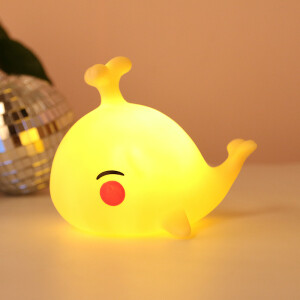 Veilleuse en silicone colorée en forme de baleine heureuse. Bonne qualité et à la mode sur une table dans une maison