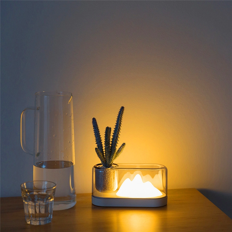 Veilleuse LED colline pour la lecture et la nuit. Bonne qualité, original, sur une table à coté d'un carafe et une verre dans une maison