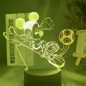 Veilleuse de mickey en train de jouer au football, la lampe se trouve sur un bureau avec des bibelots à droite et des livres à gauche