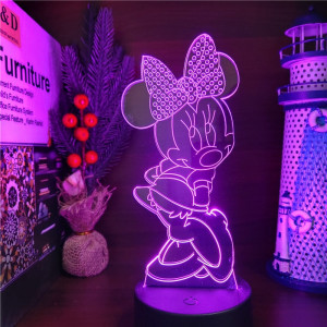 Veilleuse mini en 3D violet posée sur un bureau avec à droite un bibelot en forme de phare marin et à gauche une décoration de houx, et des livres