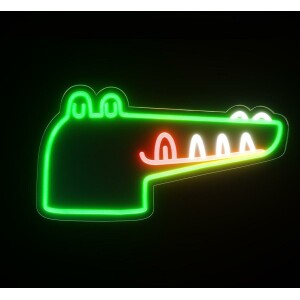 Une veilleuse crocodile en néon vert, jaune et rouge. Sur fond noir