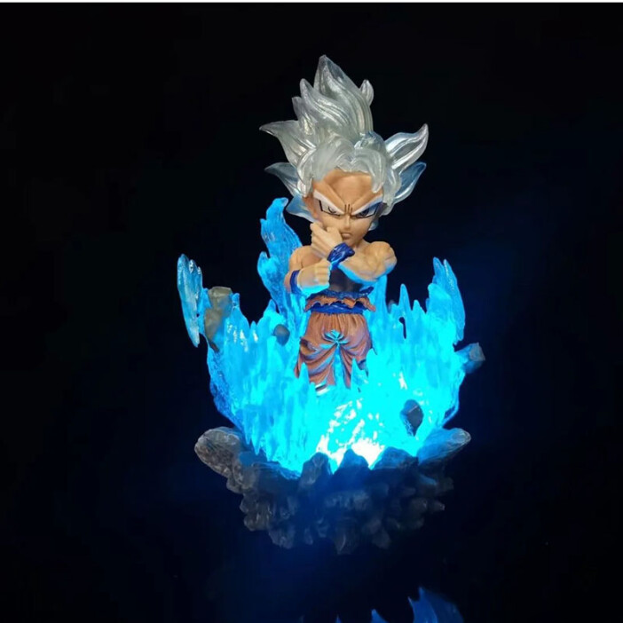 Une figurine Dragon Ball Z dans une flamme bleue. Sur fond noir.