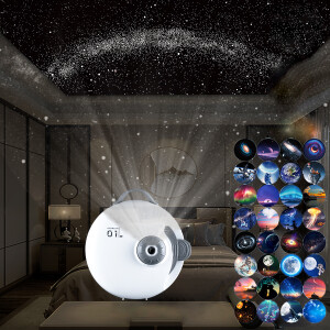 Un projecteur rond blanc qui envoie des étoiles sur le plafond et les murs. Sur la droite la liste des diaporamas disponible. En fond un salon avec un canapé, une lampe de chevet.