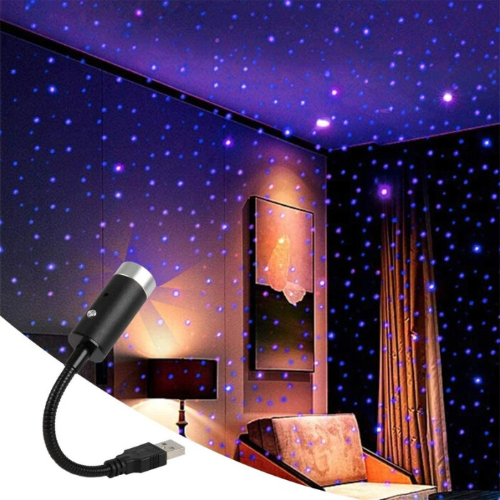 Une petite veilleuse sur câble USB noir dans le coin à gauche de l'image entrain de projeter des lumières bleues dans une chambre