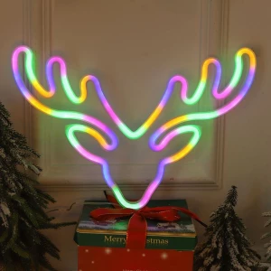 néon LED pour décoration de noël en forme de cerf multicolore posé près de cadeaux de noël
