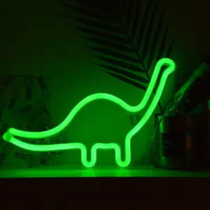 veilleuse en forme de dinosaure vert au long cou est allumée dans le noir