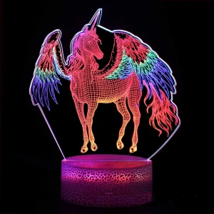 veilleuse licorne en 3D, multicolore, elle a ses ailes déployées , le socle est rose et elle est allumée dans la nuit