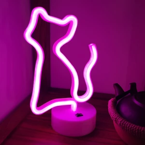 Veilleuse de nuit néon en forme de chat rose, devant un pot