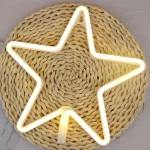 Veilleuse étoile néon jaune présenté sur un rond en osier
