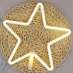 Veilleuse étoile néon jaune présenté sur un rond en osier