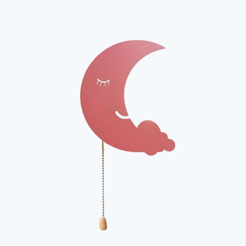 Veilleuse murale en forme de lune rose avec un trait pour l'oeil et la bouche, un nuage à la pointe du bas de la lune. Une chaînette pour l'allumage. Sur fond bleu ciel.