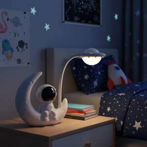 Veilleuse représentant un petit astronaute avec lumière apaisante et décor lunaire dans une chambre d'enfant posée sur la table de chevet.