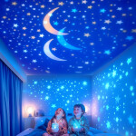 Veilleuse projecteur enfant en forme de couronne dorée, projetant une galaxie d’étoiles et de méduses colorées sur les murs et le plafond d’une chambre bleue.
